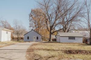 a white house and a house with a tree at Walk to Cafe & Mall, One Mile to Dordt, Dog Theme in Sioux Center