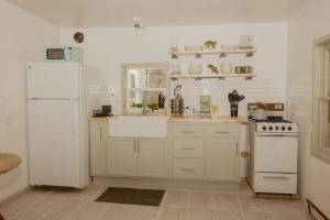 a kitchen with white appliances and a white refrigerator at Walk to Cafe & Mall, One Mile to Dordt, Dog Theme in Sioux Center +13 photos