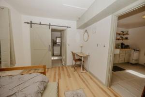 a room with a bed and a desk and a kitchen at Walk to Cafe & Mall, One Mile to Dordt, Dog Theme in Sioux Center