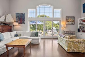 a living room with a white couch and a table at Oasis near beach Pool large yard and airy kitchen in Orleans