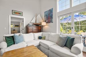 a living room with a white couch and a table at Oasis near beach Pool large yard and airy kitchen in Orleans