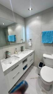 a bathroom with a toilet and a sink and a mirror at The Happy Place in San Juan +29 photos