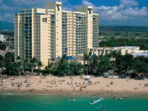 a group of people on a beach in front of a building at The Happy Place in San Juan
