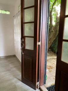 une porte ouverte sur une pièce avec un arbre dans l'établissement Karanda Cottage at Kotte, à Sri Jayewardenepura Kotte