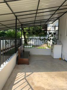 un patio avec un banc assis sur un balcon dans l'établissement Karanda Cottage at Kotte, à Sri Jayewardenepura Kotte