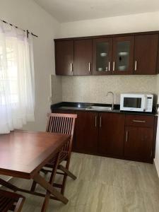 une cuisine avec une table en bois et un micro-ondes dans l'établissement Karanda Cottage at Kotte, à Sri Jayewardenepura Kotte