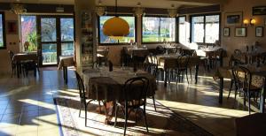 a dining room with tables and chairs and windows at Les Rochers in Saint-Savin
