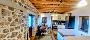 a kitchen with a stone wall and a table at Villa Pialia in Piáleia