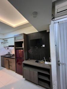 バンドンにあるTHE JARRDIN CIHAMPELAS by RA APARTMENT NEWの木製のキャビネットとカウンタートップを備えたキッチン