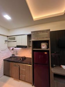 バンドンにあるTHE JARRDIN CIHAMPELAS by RA APARTMENT NEWのキッチン(赤い冷蔵庫、シンク付)