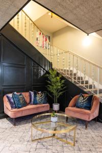 a living room with two couches and a glass table at The Monterey Hotel, BW Signature Collection in Saint Helier Jersey