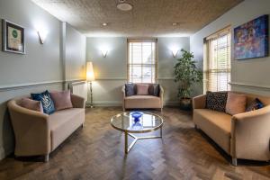 a living room with two couches and a glass table at The Monterey Hotel, BW Signature Collection in Saint Helier Jersey