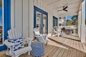 un portico con sedie a dondolo bianche e un uccello di Gilligan's Island a Inlet Beach