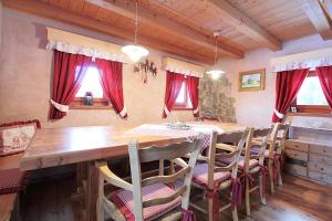 a dining room with a wooden table and chairs at Baita Mountain View Pale San Martino in Fiera di Primiero +15 photos