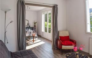 ein Wohnzimmer mit einem roten Stuhl und einem Tisch in der Unterkunft Holiday Home Plouha 10 in Plouha + 20 Fotos