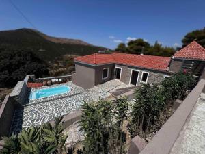 a house with a swimming pool on top of it at Land Of Olive in Kápsala