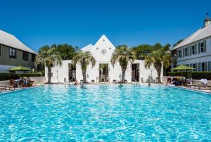 a large swimming pool in front of a building at Belize Carriage House in Rosemary Beach