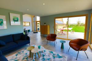 a living room with a couch and chairs and a table at Chez Watersy in Belle-et-Houllefort