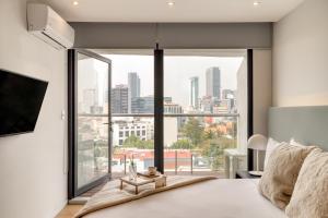 1 dormitorio con ventana grande con vistas a la ciudad en ULIV Mexico City, en Ciudad de México