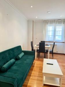 a living room with a green couch and a table at La Perla del Castro in Vilagarcia de Arousa