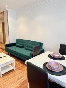 a living room with a green couch and a table at La Perla del Castro in Vilagarcia de Arousa