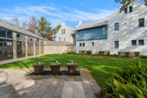 a yard with a building and a courtyard with three baskets at Brighton Carriage House in Rosemary Beach