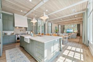 a kitchen with blue cabinets and a dining room at Beach Bear Cottage in Watersound Beach