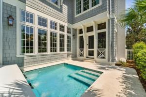 a swimming pool in front of a house at Beach Bear Cottage in Watersound Beach