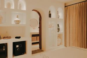 a room with white shelves with vases and a mirror at Inlander Villas A- Private pool luxury Villa in Gili Trawangan +26 photos