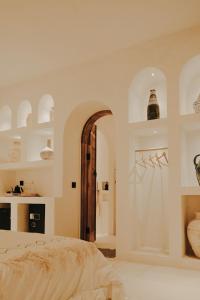 a white bedroom with a bed and an archway at Inlander Villas A- Private pool luxury Villa in Gili Trawangan