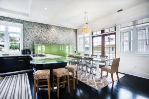 a kitchen with green cabinets and a table with chairs at Benoit Cottage in Rosemary Beach