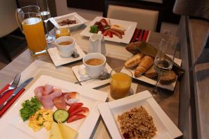 a table topped with plates of food and drinks at Boutique Hotel Villa ZAUBER in Poprad