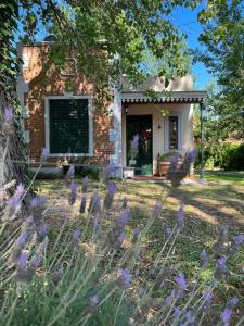 a house with purple flowers in front of it at Santa Teresita en el monte in Santa Teresita