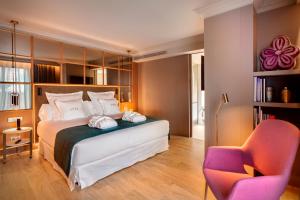 - une chambre avec un lit et une chaise dans l'établissement Barceló Emperatriz, à Madrid