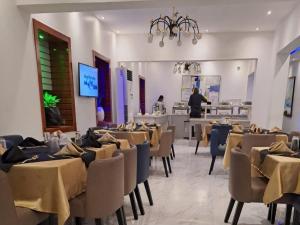 a restaurant with tables and chairs and a chef in the background at Royal Rex Hotels and Spa in Lagos
