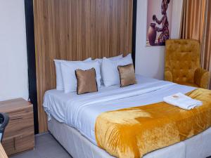 a bedroom with a large bed and a chair at Royal Rex Hotels and Spa in Lagos +42 photos