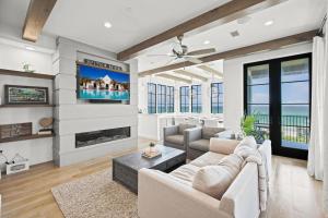 a living room with a couch and a tv at Oasis Cottage & Carriage House in Rosemary Beach