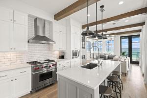a kitchen with white cabinets and a kitchen island at Oasis Cottage & Carriage House in Rosemary Beach