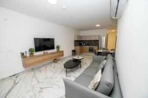 una sala de estar con un sofá y una mesa en Modern Escape 3-Bedroom Maisonette with Free Parking, en St Paul's Bay