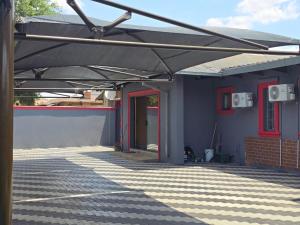 un edificio azul con toldo en un patio en Botshe Lodge in Vanderbiljpark, en Vanderbijlpark