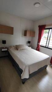a bedroom with a large bed and a window at Chill Out Piria 3 in Piriápolis