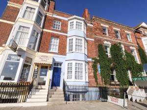 a large brick building with a blue door at One No36 in Weymouth