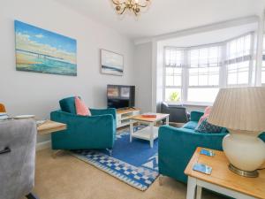 Una sala de estar con sillas azules y una mesa. en Two No36, en Weymouth