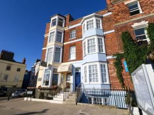 un gran edificio de ladrillo con puerta azul en Two No36, en Weymouth