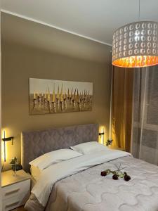 a bedroom with a large bed and a chandelier at BolognaBySide -RIGHI in Bologna