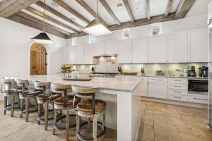 a kitchen with a large island with bar stools at Water Cottage and Carriage House in Rosemary Beach