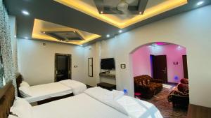 a hotel room with two beds and a couch at The Bastian Palace in Rānchī