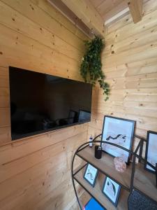 a room with a wooden wall with a tv and a table at L'Ecrin des Sentiers in La Bruyère +66 photos