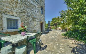 a table and chairs in front of a stone building at Cozy Home In Kastel With Wifi in Kaštel