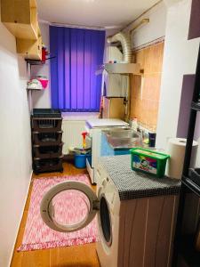 a laundry room with a washing machine and a purple window at Apartment boulevard Cetate in Alba Iulia
